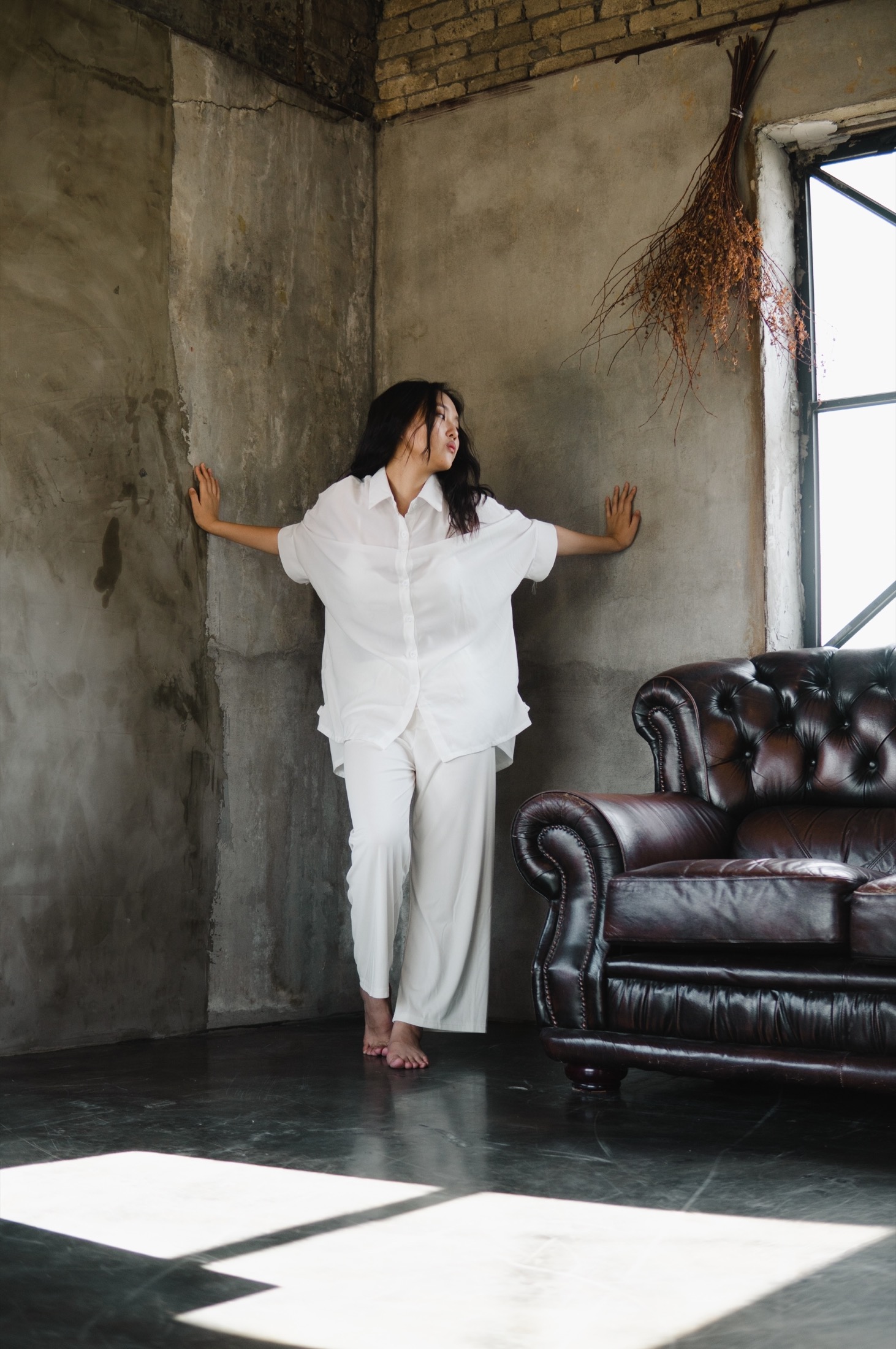 Portrait in industriellem Raum mit Sofa und Licht